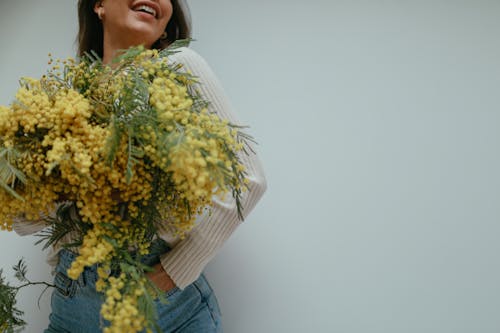 Foto profissional grátis de calça jeans, flores amarelas, jeans