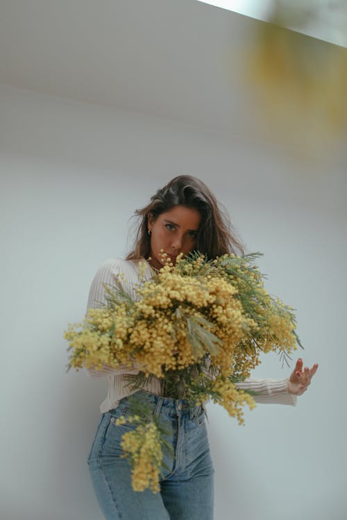 Beyaz duvar, çiçek tutan, dikey atış içeren Ücretsiz stok fotoğraf