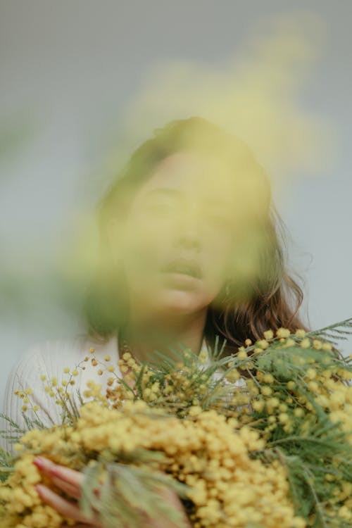 Gratis arkivbilde med gule blomster, holder blomster, kvinne