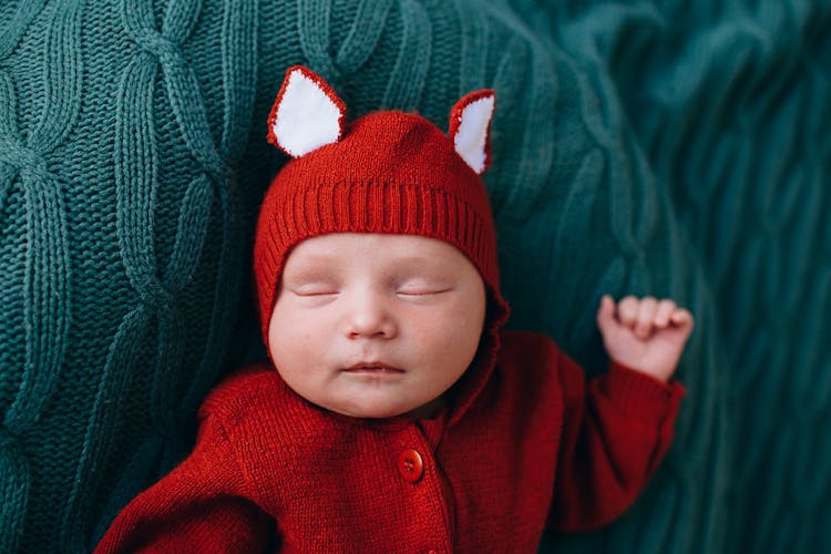 Adorable Sleeping Baby In Red Woolen Costume