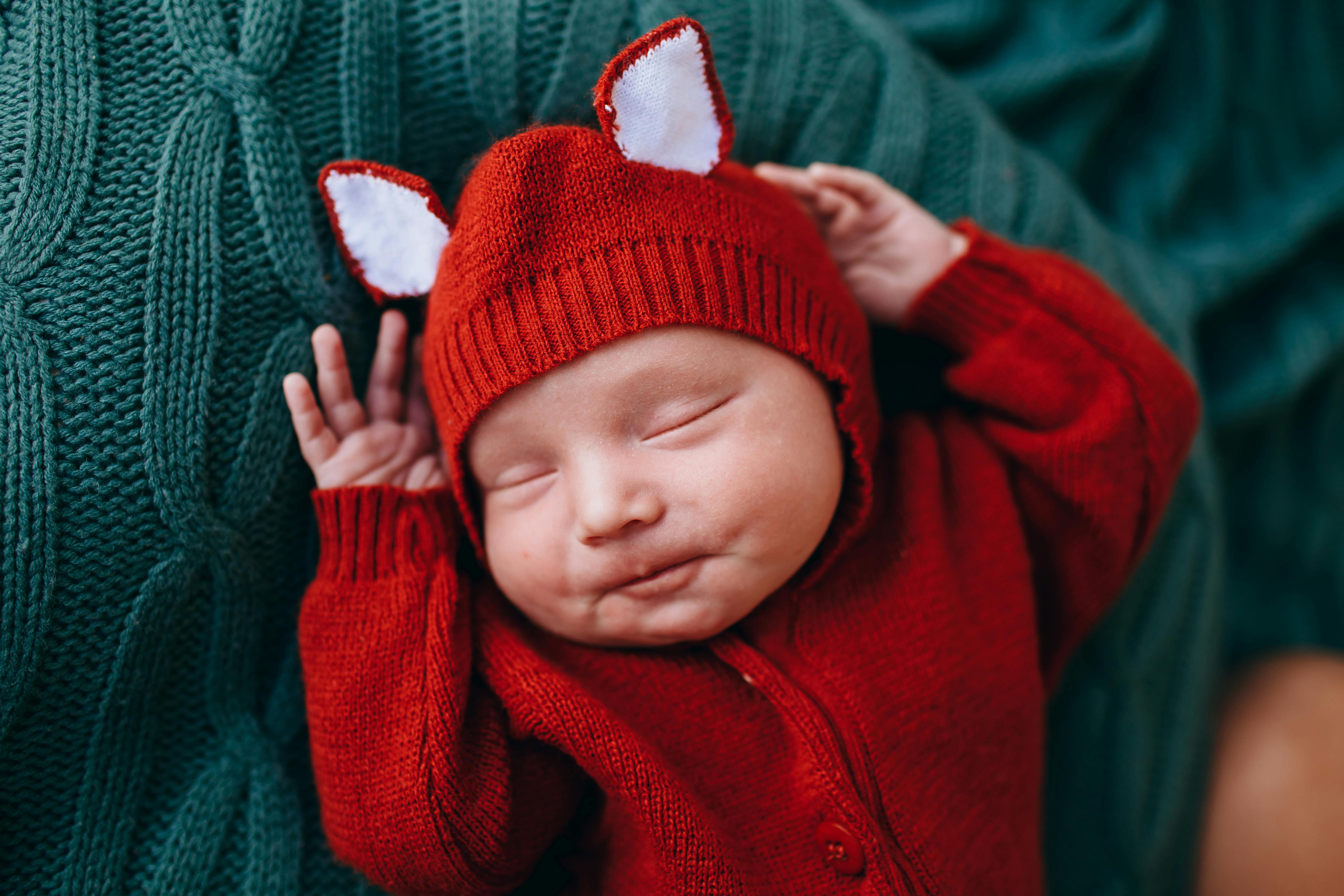 happy cute funny baby in knitted red costume