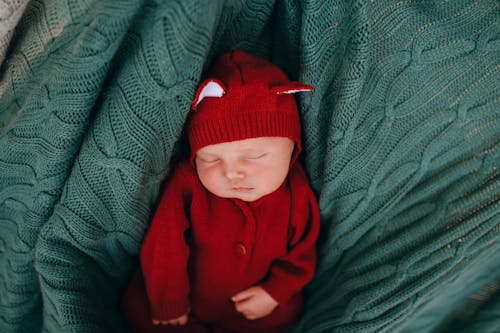 Free Top view of funny little cute calm infant sleeping in blue knitted blanket Stock Photo