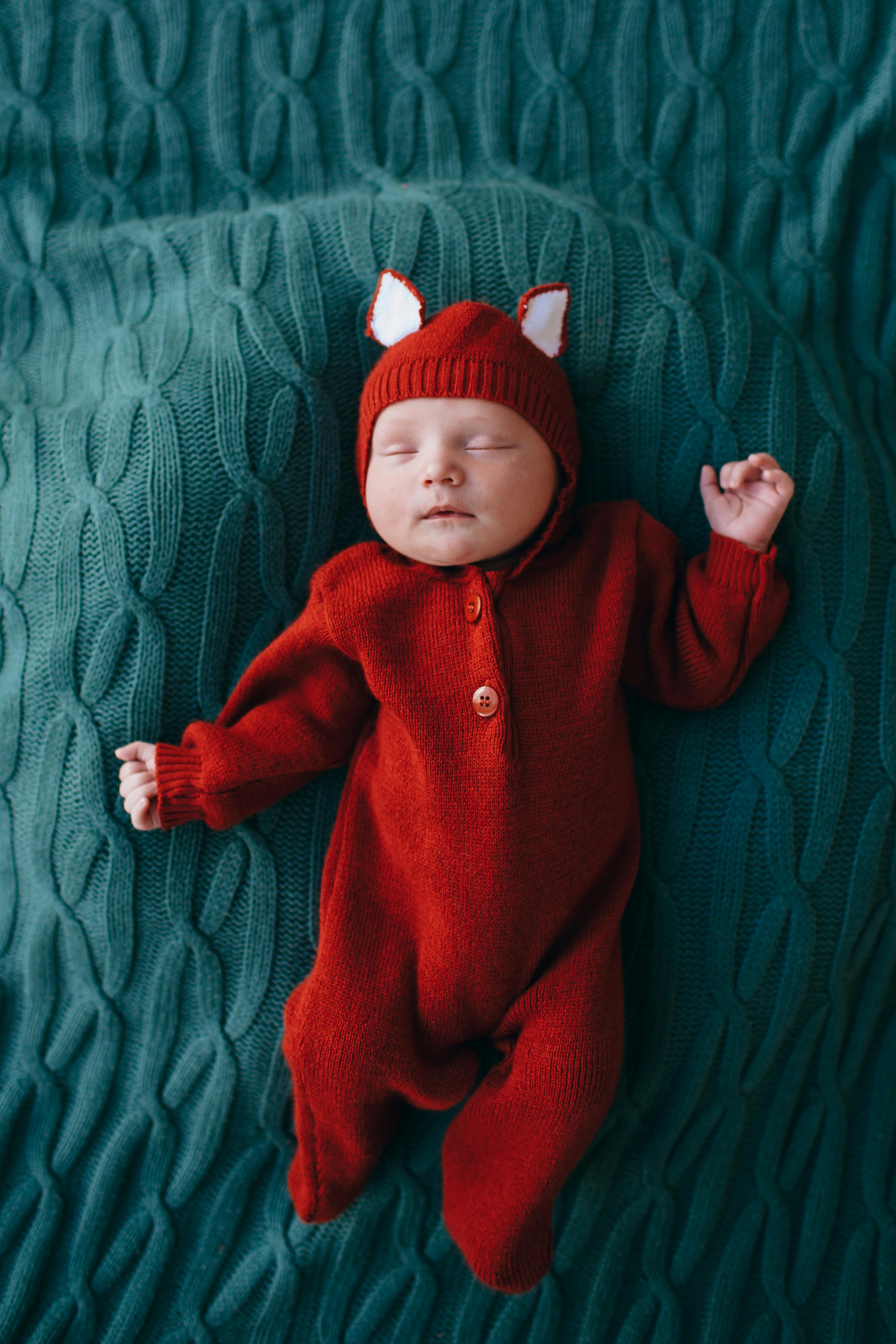 cute little baby in funny red woolen costume with ears
