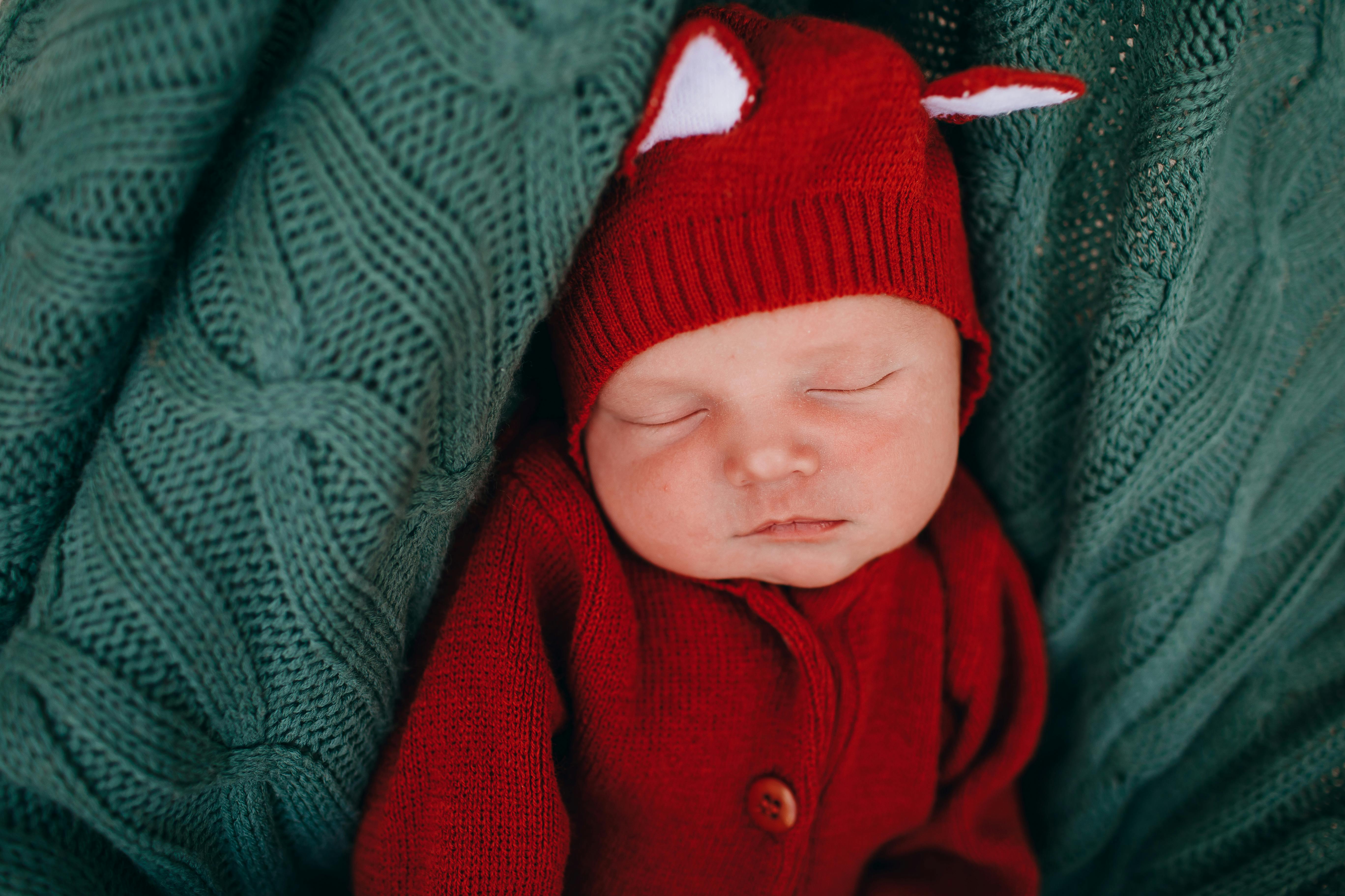 little cute baby resting in knitted blue blanket