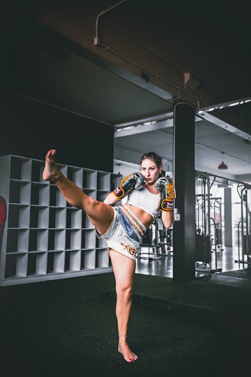 Young woman with leg raised kickboxing