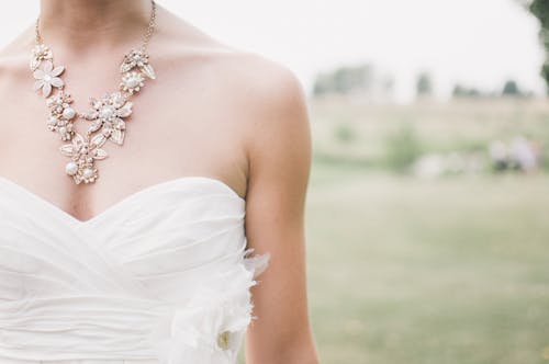 Free Woman in White Dress Wearing Gold Chunky Necklace during Daytime Stock Photo
