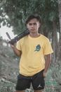 Man in Yellow Crew Neck T-shirt Holding Rifle