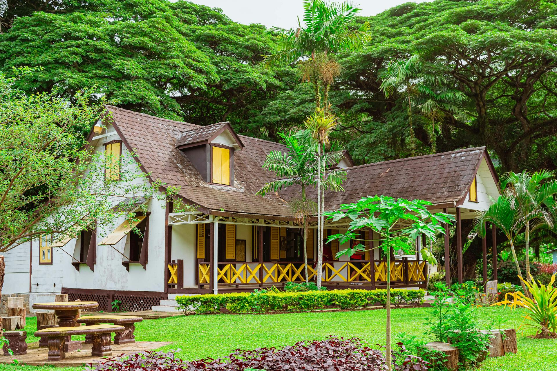 A picturesque wooden bungalow surrounded by lush greenery in Lopinot, Trinidad and Tobago.