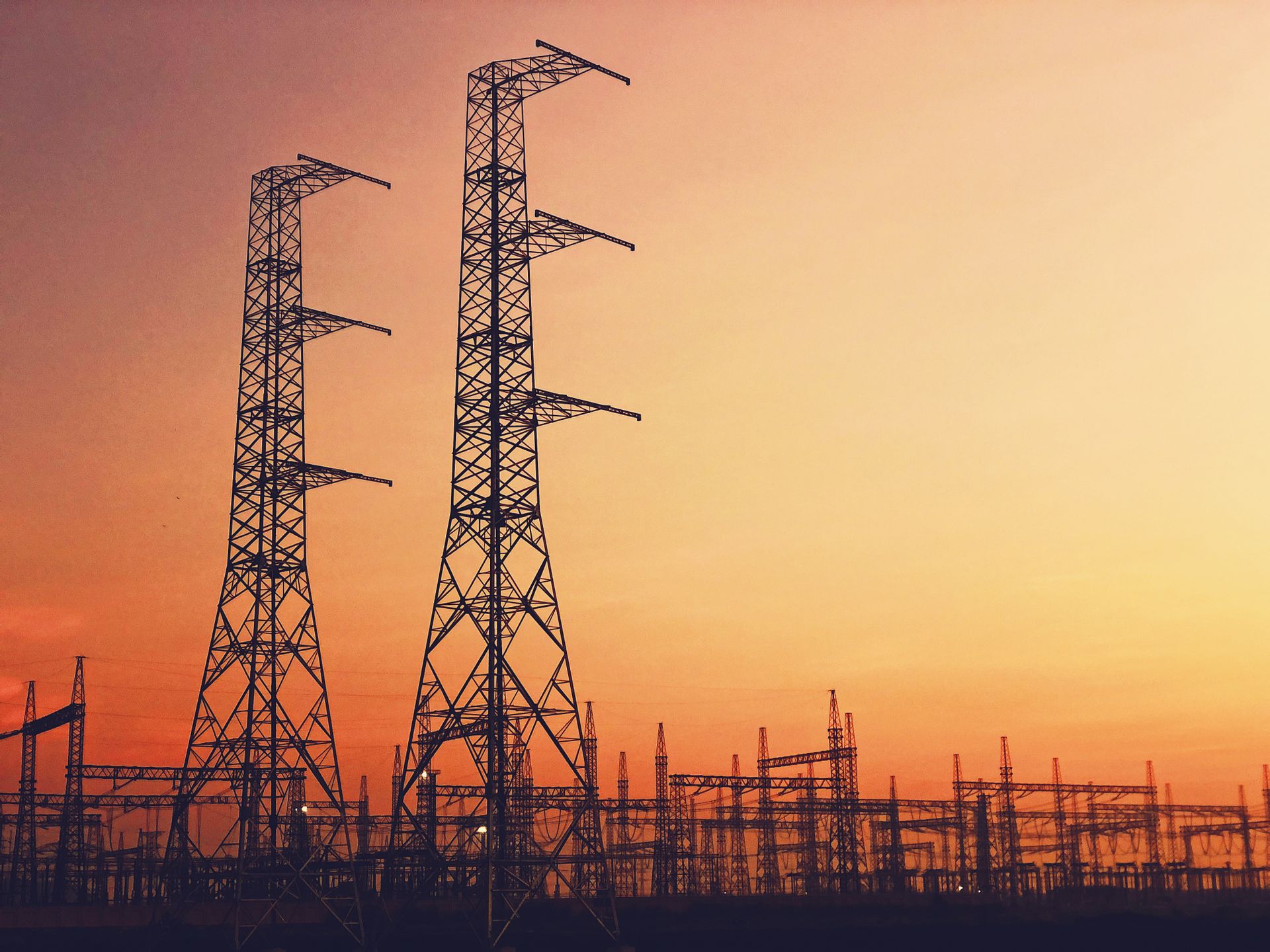 Power plant towers silhouetted against a vibrant sunset in Quảng Ngãi, showcasing industrial strength.
