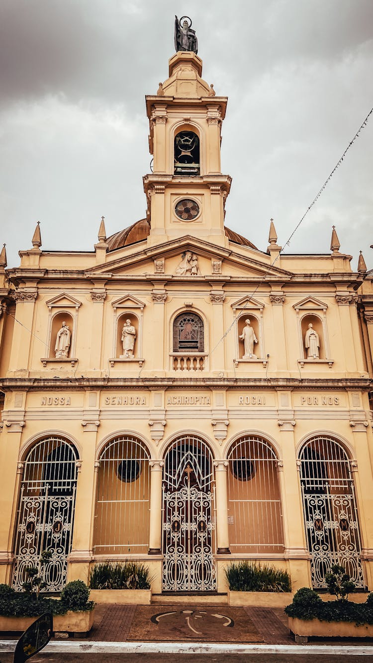 Cloudy Sky Over Aged Catholic Church With Bell Tower