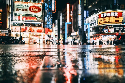 Asphalt road with vehicles near glowing buildings with hieroglyphs on signboards near people at night city