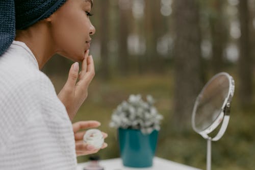 Woman Applying a Beauty Product on Her Face