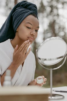 A woman applying face cream during a calming beauty routine with a mirror reflection.
