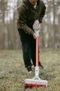 Person in Black Jacket Holding Red and White Stick