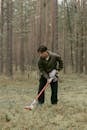 Man in Gray Jacket Holding Red and White Stick