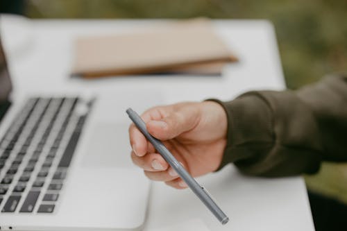 Free A Person Holding a Pen  Stock Photo