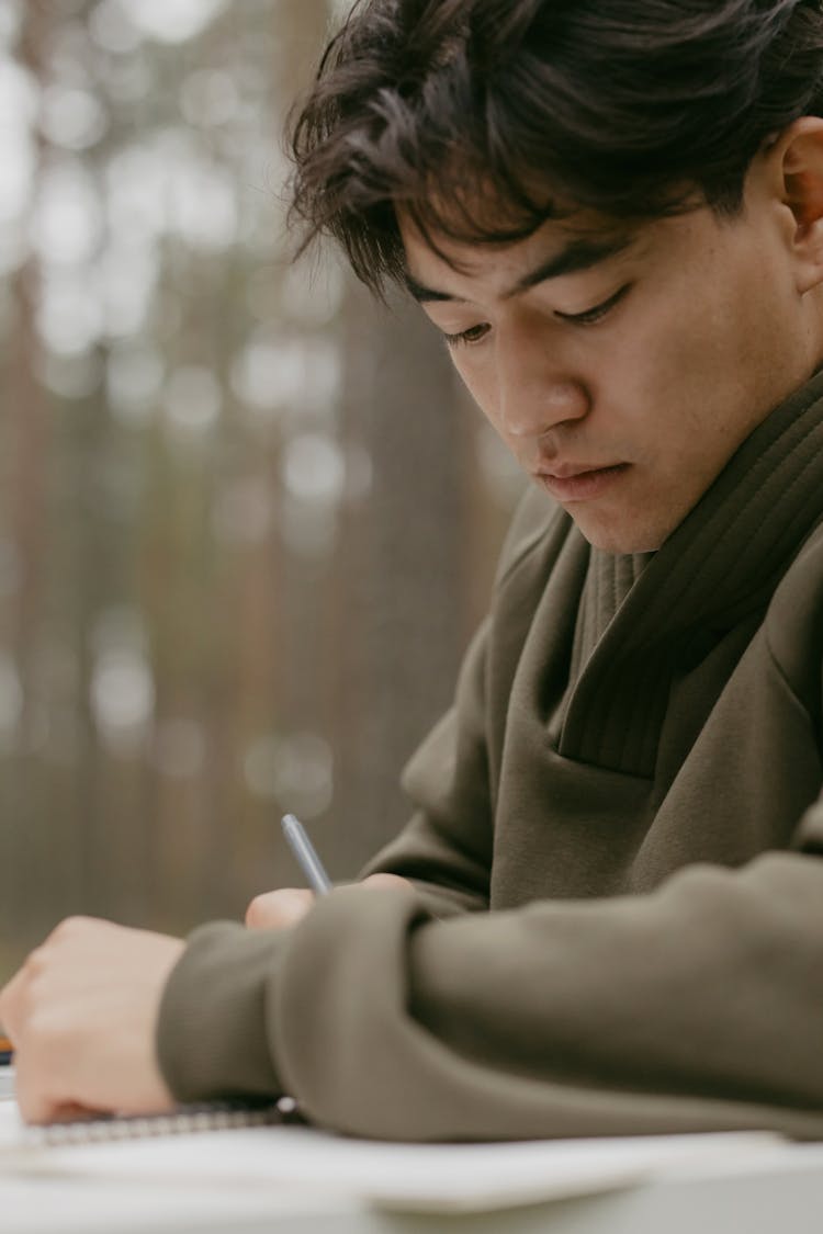 A Man Writing Using A Pen