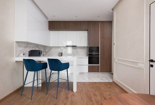 Free Interior of modern kitchen with comfortable chairs placed near table cabinets and appliances Stock Photo