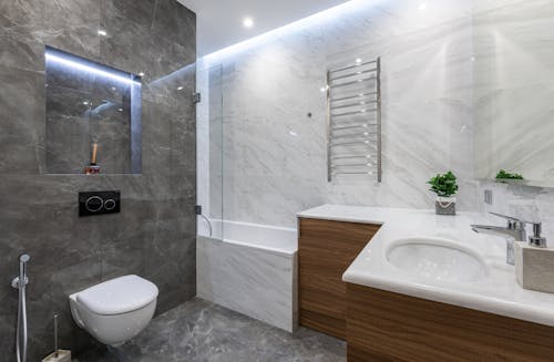 Interior of contemporary bathroom with white washbasin bathtub and toilet with bidet in modern apartment