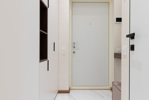 Free Interior of corridor of modern apartment with white wardrobe and wooden shelves near entrance door Stock Photo