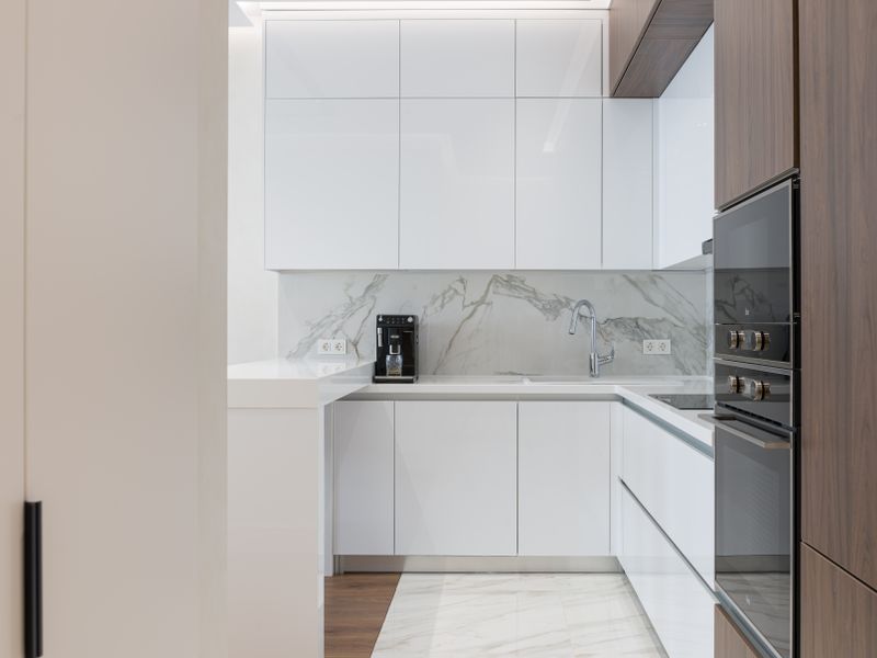 Appliance that needs same-day repair in Kirkland Minimalist interior of small kitchen with white and wooden cupboards and modern appliances in light apartment