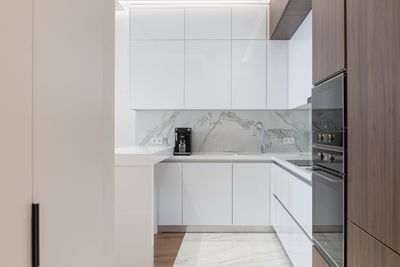 Compact white kitchen with wooden cabinets — photo by Max Vakhtbovych on Pexels