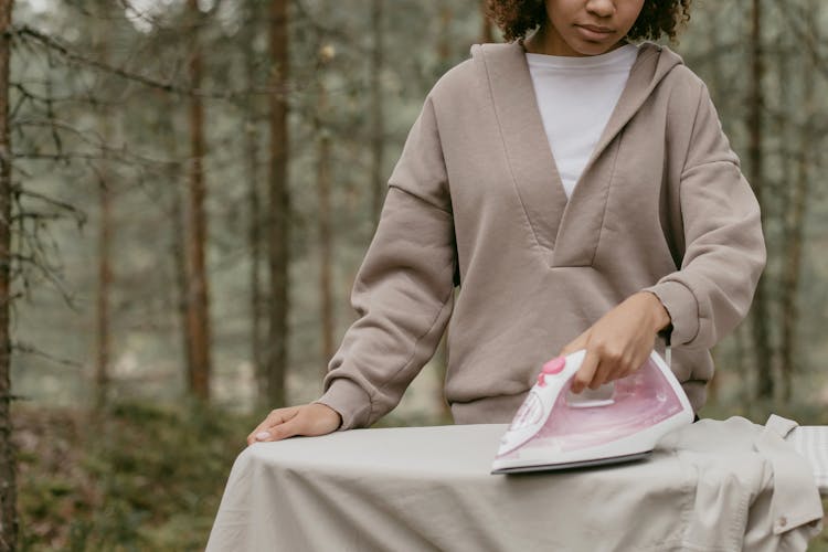 Photo Of A Girl Ironing A Shirt