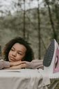 A Woman Resting On An Ironing Board and Daydreaming