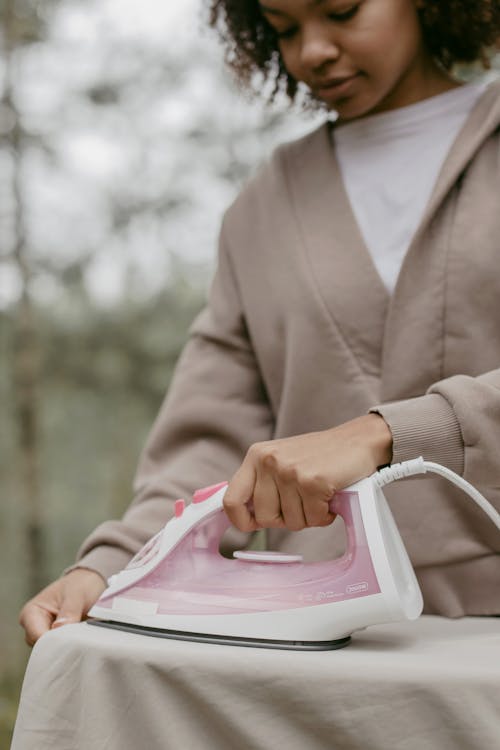 Free A Young Woman Ironing Outside Stock Photo