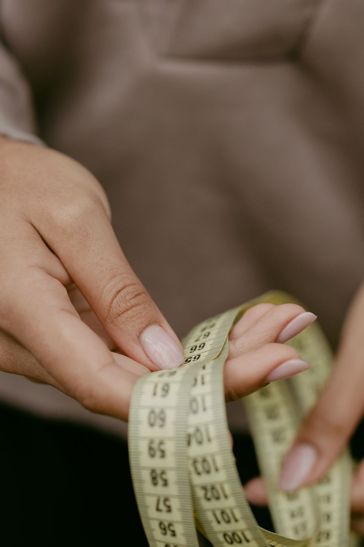 Hands holding a measuring tape representing traditional weight-loss affiliate offers like fitness and diet programs