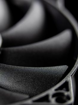 Detailed macro shot of a computer cooling fan showcasing its blades in grayscale tones.