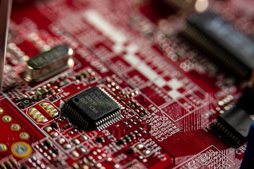 Detailed macro shot of a red circuit board, highlighting electronic components and microchips.