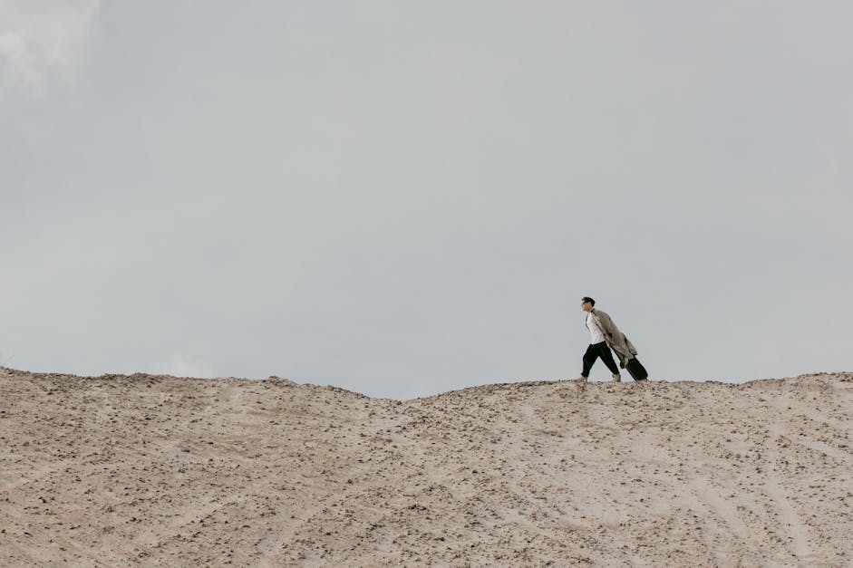 Man Walking On Dry Land With A Luggage · Free Stock Photo