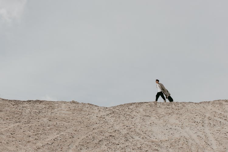 Man Walking On Dry Land With A Luggage