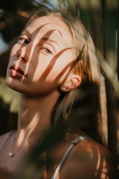 Free Artistic portrait of a woman in Bali with dramatic sunlight and shadows accentuating her features. Stock Photo