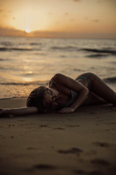 Woman relaxing on Bali beach at sunset, capturing the serene beauty and tranquility of the moment.