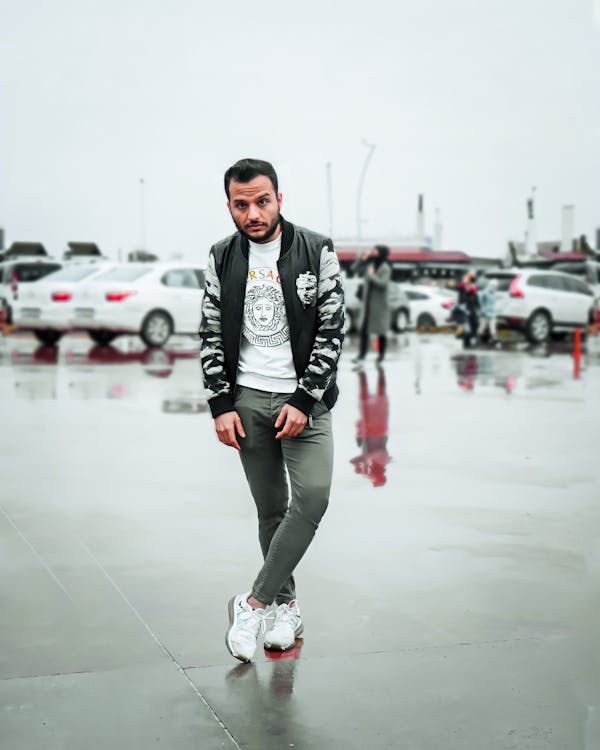 A Man in Printed Jacket and Gray Pants Standing on the Street