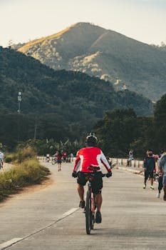 A cyclist rides down a scenic mountain road, embracing the healthy lifestyle of outdoor biking.