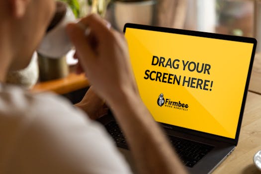 A man drinking coffee while working on a laptop indoors, focusing on remote work.