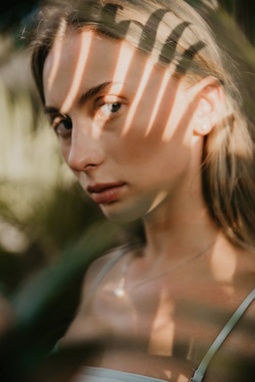 A Woman in White Tank Top Looking with a Serious Face