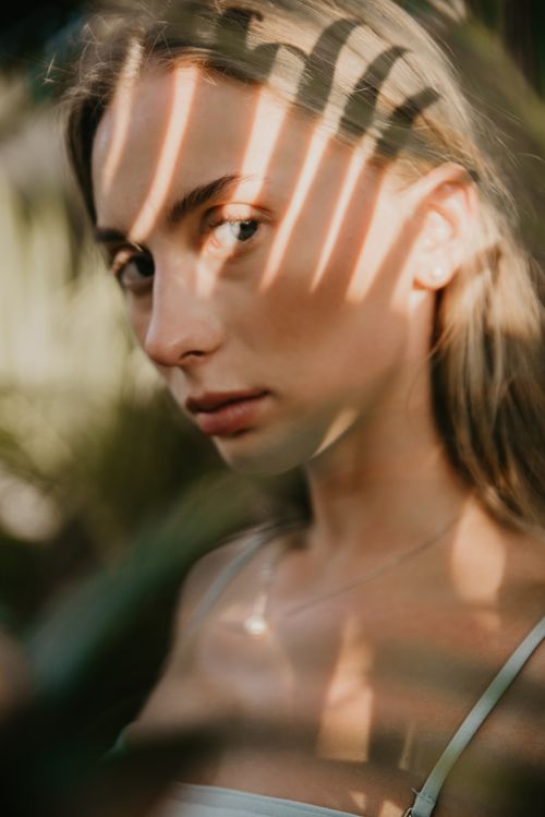 Free Close-up portrait of a woman with shadow patterns on her face, captured outdoors in Bali. Stock Photo