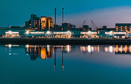 Illuminated skyline at night reflecting in the Thames near London City Airport.