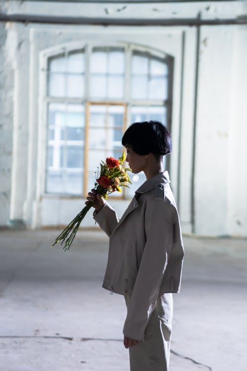 Side View of a Woman Smelling a Bouquet of Flowers