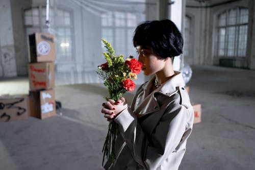 Woman In Beige Coat Holding Bouquet Of Flowers