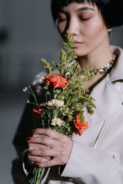 A Woman Smelling a Bouquet of Flowers