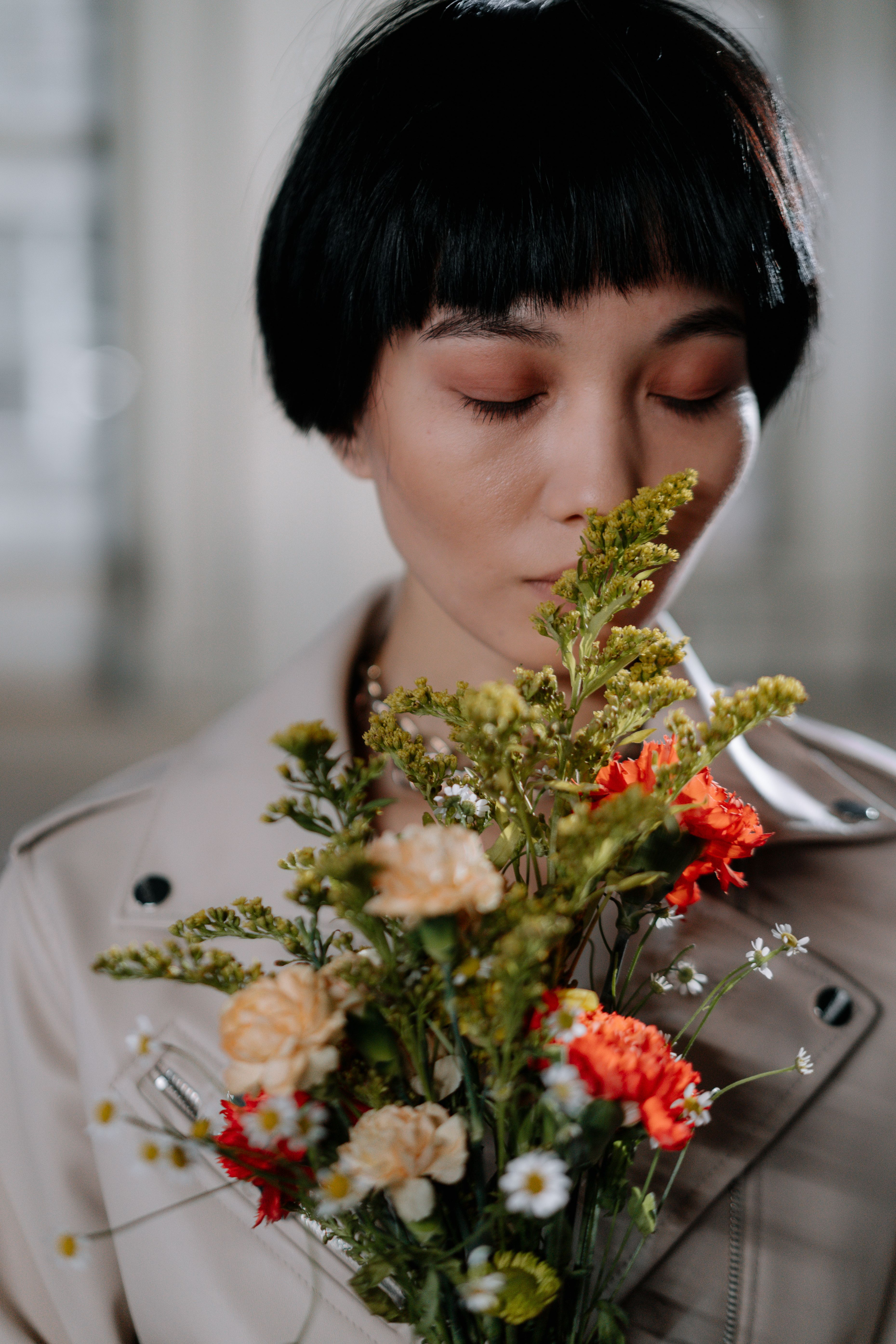 A Short Haired Woman Smelling a Bunch of Flowers with Her Eyes Closed ...
