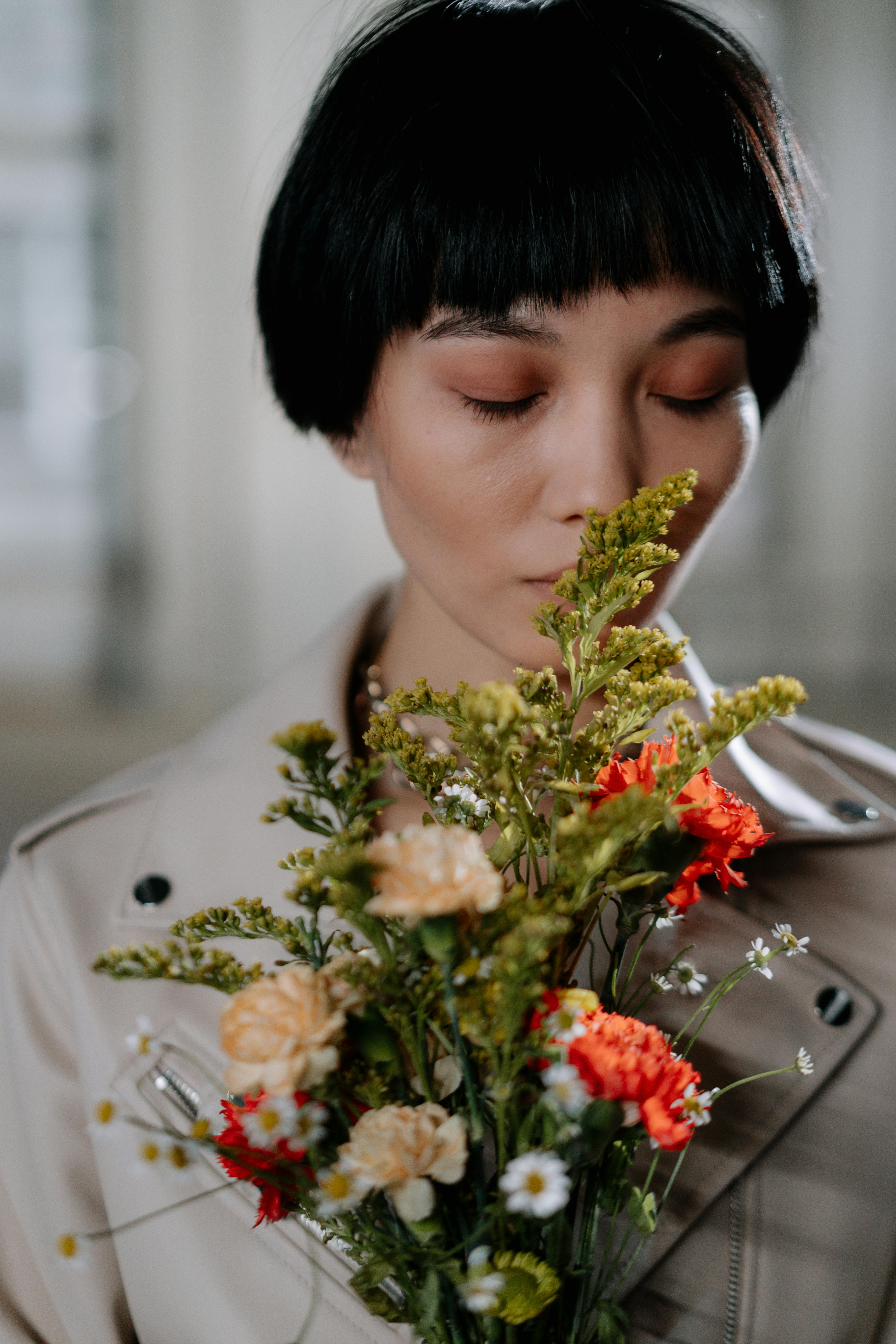 A Woman Smelling Flower while Closed Eyes · Free Stock Photo