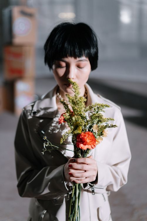 Free Peaceful portrait of a woman holding a bouquet, symbolizing nonviolence and tranquility. Stock Photo