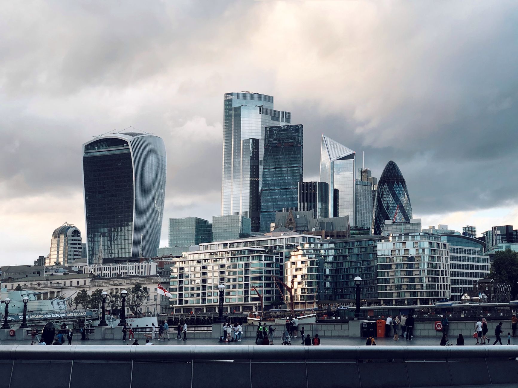 View of London's iconic skyscrapers including The Walkie Talkie and The Gherkin under a cloudy sky.