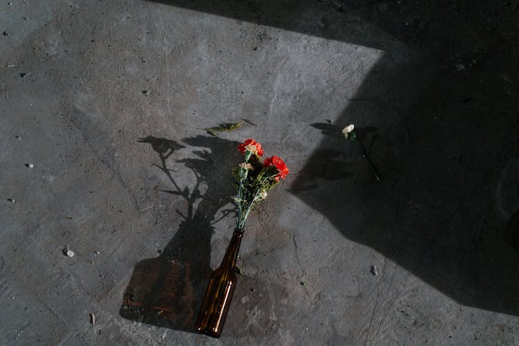 Red And White Flower Bouquet On Gray Concrete Floor